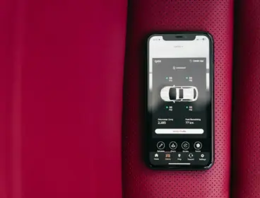 Smartphone displaying car control app on red seat